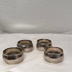 These vintage napkin rings appear to be silver-plated,withdecorative border trim